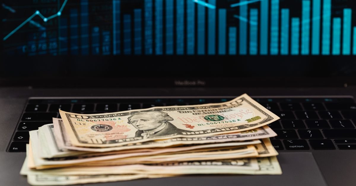Rekening USD freelancer Indonesia 2026 — lembaran dolar di atas laptop, ilustrasi perbandingan Grey, Payoneer, dan Wise untuk nerima gaji freelance